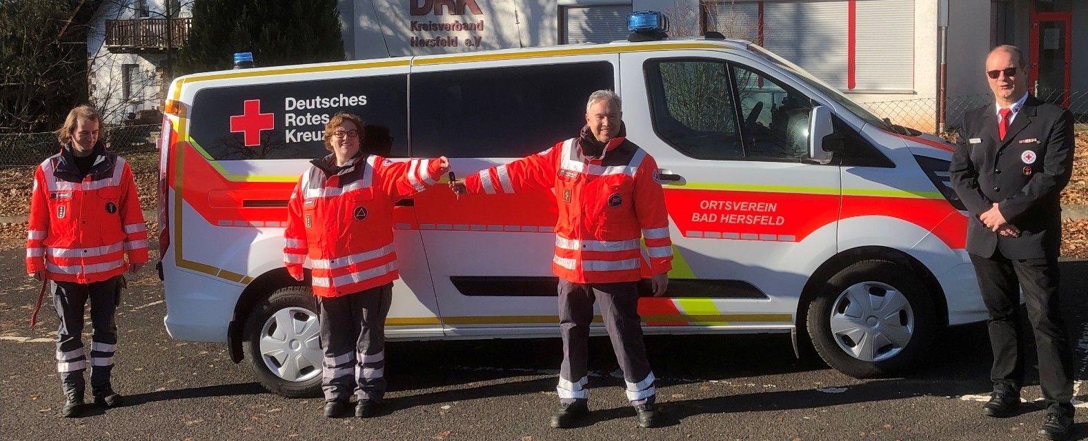 Foto: Zwei ältere Damen lehnen sich aus einem großen Fenster und blicken freudig den nahenden DRK-Mitarbeiter an.